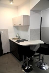 a kitchen with a sink and a counter with chairs at Motel Dymek in Dębica