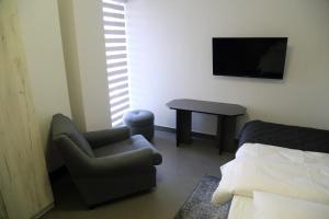 a living room with a chair and a tv and a table at Motel Dymek in Dębica