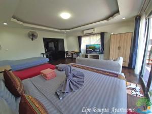 uma sala de estar com uma cama e um sofá em Lipe Banyan Apartments em Ko Lipe
