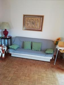 a blue couch with green pillows in a living room at Apartmaji Karbic in Postojna