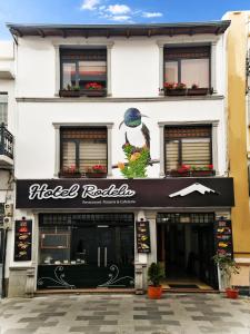 una tienda frente a un edificio con un cartel. en Hotel Rodelu en Latacunga