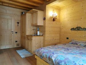a bedroom in a log cabin with a bed and a sink at Vista Pelmo in Colle Santa Lucia