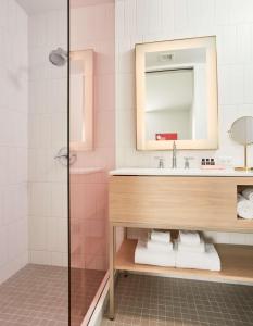 a bathroom with a sink and a mirror at Quirk Hotel Charlottesville in Charlottesville