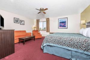 a hotel room with a bed and a couch at Days Inn by Wyndham Pueblo in Pueblo