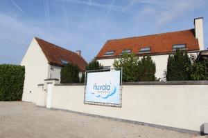 a sign on a white fence in front of a house at NUVOLA VILLA in Zottegem