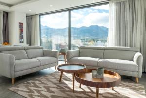 a living room with two couches and a large window at Deluxe Apt w/ Rooftop Pool in The Heart of Kyrenia in Kyrenia