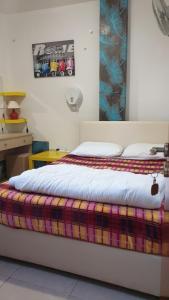 a bedroom with a bed with a colorful blanket on it at Marina's Rooms in Larnaca