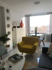 a living room with a yellow chair and a table at La Mata Beach - Studio - Appartement - Miramar XI - Torrevieja in Torrevieja +40 photos