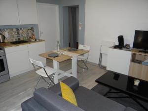 een woonkamer met een bank en een tafel en een keuken bij Bonne Nouvelle in Saint-Jean-de-Maurienne