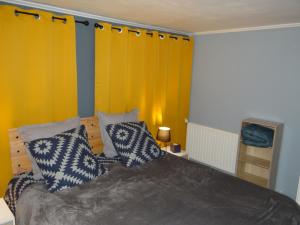 een slaapkamer met een bed met blauwe en witte kussens bij Bonne Nouvelle in Saint-Jean-de-Maurienne