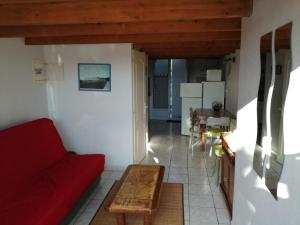 een woonkamer met een rode bank en een tafel bij abri/cotier in Châtelaillon-Plage
