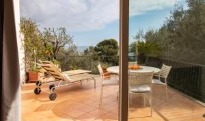 a patio with a table and chairs on a balcony at Casa Pineta in Diano Marina
