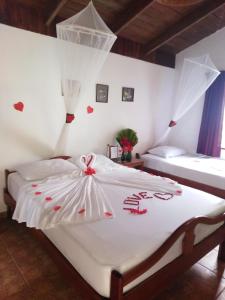 a bedroom with a white bed with hearts on it at Escape Caribeño in Puerto Viejo