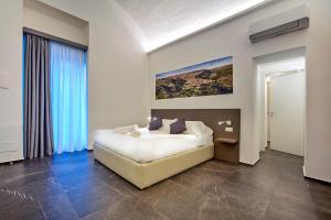 1 dormitorio con 1 cama y una pintura en la pared en Ad Maiora - Design Rooms, en Ragusa