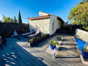 a deck with two benches and a house at Appartement La Perle Noire in Agde