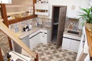 una pequeña cocina con armarios blancos y fregadero en Luxusní Apartmán NMNM Mezonet, en Nové Město na Moravě