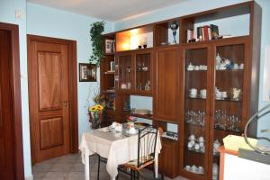 ein Esszimmer mit einem Tisch und einem großen Bücherregal aus Holz in der Unterkunft B&B Il Girasole in Assemini