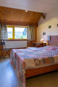 une chambre avec un lit, une table et une fenêtre dans l'établissement Gite Panda La Sylve, à Tenneville