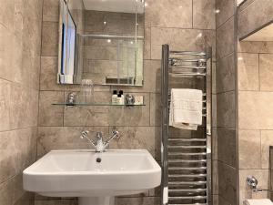 y baño con lavabo y espejo. en Glenalmond House, en Edimburgo