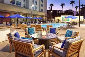 Cambria Hotel & Suites Anaheim Resort Area في أنهايم: فناء مع طاولة وكراسي ومسبح