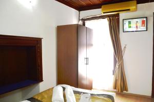 a bedroom with a bed and a tv and a window at Konak Hotel Kaleiçi in Antalya