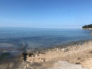 a beach with rocks and water on a sunny day at Apartman Voch in Zambratija