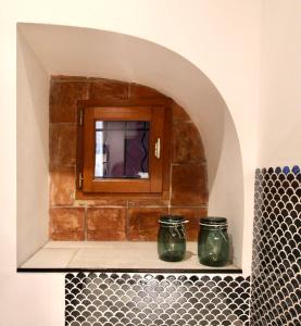 佩澤納斯的住宿－Pézenas Cocoon，浴室内两个绿色的罐子,放在架子上