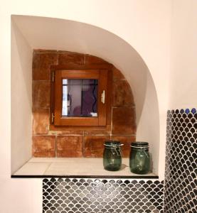 two green jars sitting on a shelf in a bathroom at Pézenas Cocoon in Pézenas