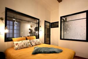 a bedroom with a large bed with a large window at Pézenas Cocoon in Pézenas