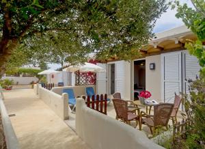 a patio with chairs and tables on a house at Es Garrovers - Formentera Break in San Ferrán de ses Roques