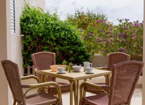 een tafel en stoelen met kopjes en kommen op een patio bij Es Garrovers - Formentera Break in Sant Ferran de Ses Roques