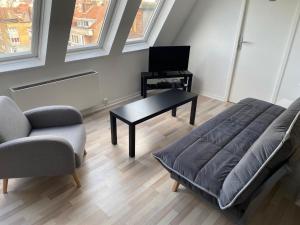 un soggiorno con divano e tavolo di Appartement 300m Plage a Dunkerque