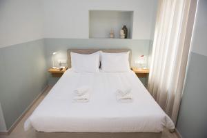 - une chambre avec un grand lit blanc et 2 tables de chevet dans l'établissement Stylish Studio Apartment - 1 House, à Kalamata