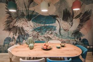 una sala da pranzo con tavolo e parete con uccelli di ROOMS LibertyHouse Firenze a Firenze