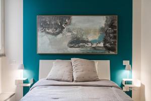 a bedroom with a bed with a painting above it at ROOMS LibertyHouse Firenze in Florence