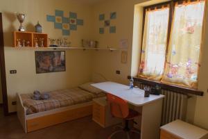 a small room with a bed and a desk at casa vacanze al paesello in Orezzo
