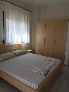 a bedroom with a large bed and a window at Lemon Flowers Apartments in Nea Skioni