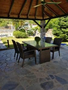 a patio with a table and chairs on a patio at Lemon Flowers Apartments in Nea Skioni