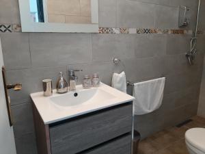 a bathroom with a white sink and a toilet at Casa Coloridos in Óbidos
