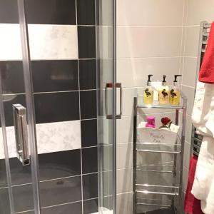 La salle de bains est pourvue d'une douche et de carrelage noir et blanc. dans l'établissement Garron View, à Cushendall