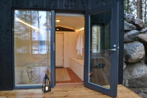 baño con una puerta de cristal que conduce a una ducha en Ilveslinna, en Laukaa