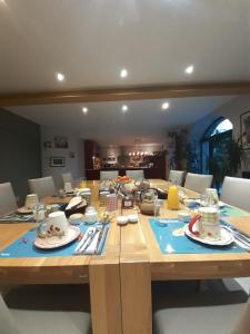 a large wooden table with plates and dishes on it at Retour aux Sources in Gouberville