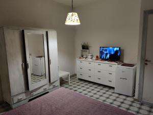 uma casa de banho com um espelho e uma cómoda com uma televisão em Holiday Home Sulmare em Isola delle Femmine