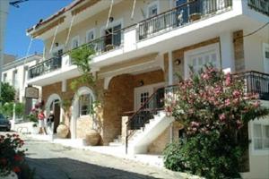 un gran edificio blanco con escaleras y balcones en PHILOXENIA PENSION en Ermioni