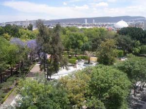 a park with trees and a dome in the distance at Hotel Amberes in Quer&eacute;taro