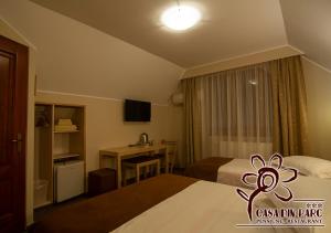 a hotel room with two beds and a desk at Casa din Parc in Covasna