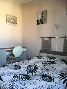 a bedroom with a bed and a desk and a chair at Le Narval in Saint-Jean-de-Monts