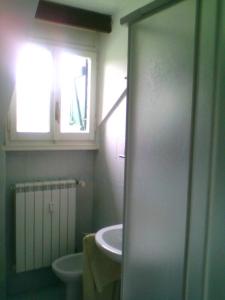 a bathroom with a sink and a toilet and a window at appartamento Prato Verde I in Pescasseroli