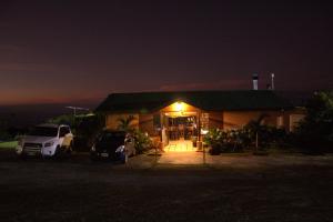 Una casa por la noche con coches aparcados delante de ella en Eco Granja Don Lolo, en Quesada