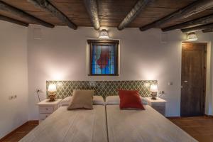 a bedroom with a bed with two lamps and a stained glass window at Al Agia - Mirador Alto Cijancos in Padul